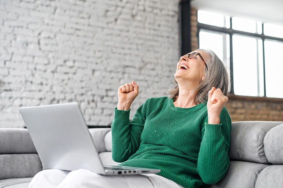 Relieved Woman celebrates after getting tech support for her laptop from tech relief